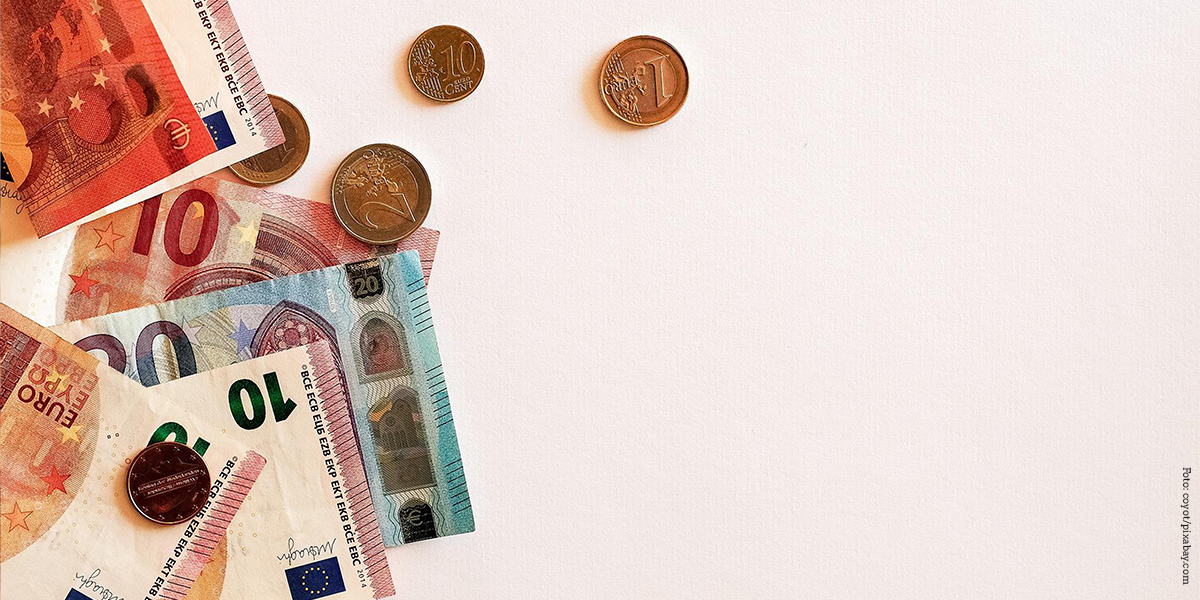 KI generiert: Das Bild zeigt Euro-Banknoten und Euro-Münzen auf einer hellen Oberfläche. Hauptinhalt sind die verschiedenen Euro-Scheine und -Münzen, die teilweise verteilt sind.