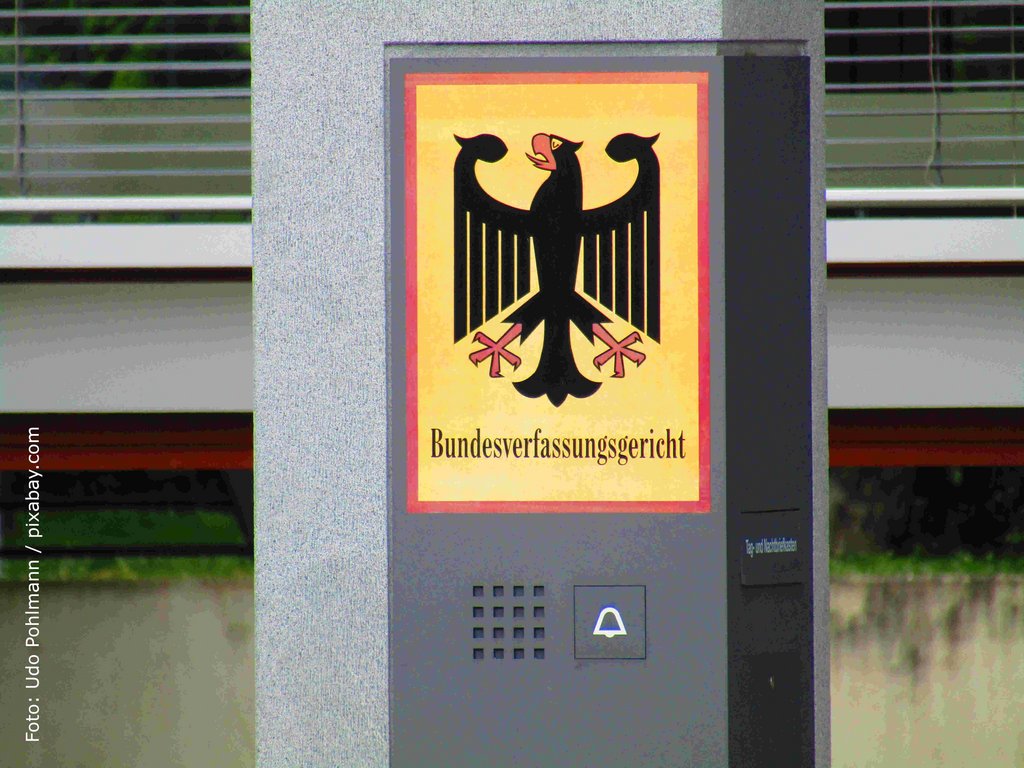 KI generiert: Das Bild zeigt ein Schild des Bundesverfassungsgerichts mit dem Bundesadler darauf. Es befindet sich an einer Gegensprechanlage oder einem Eingangssystem.